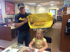Decorative image of father and daughter with a large library card