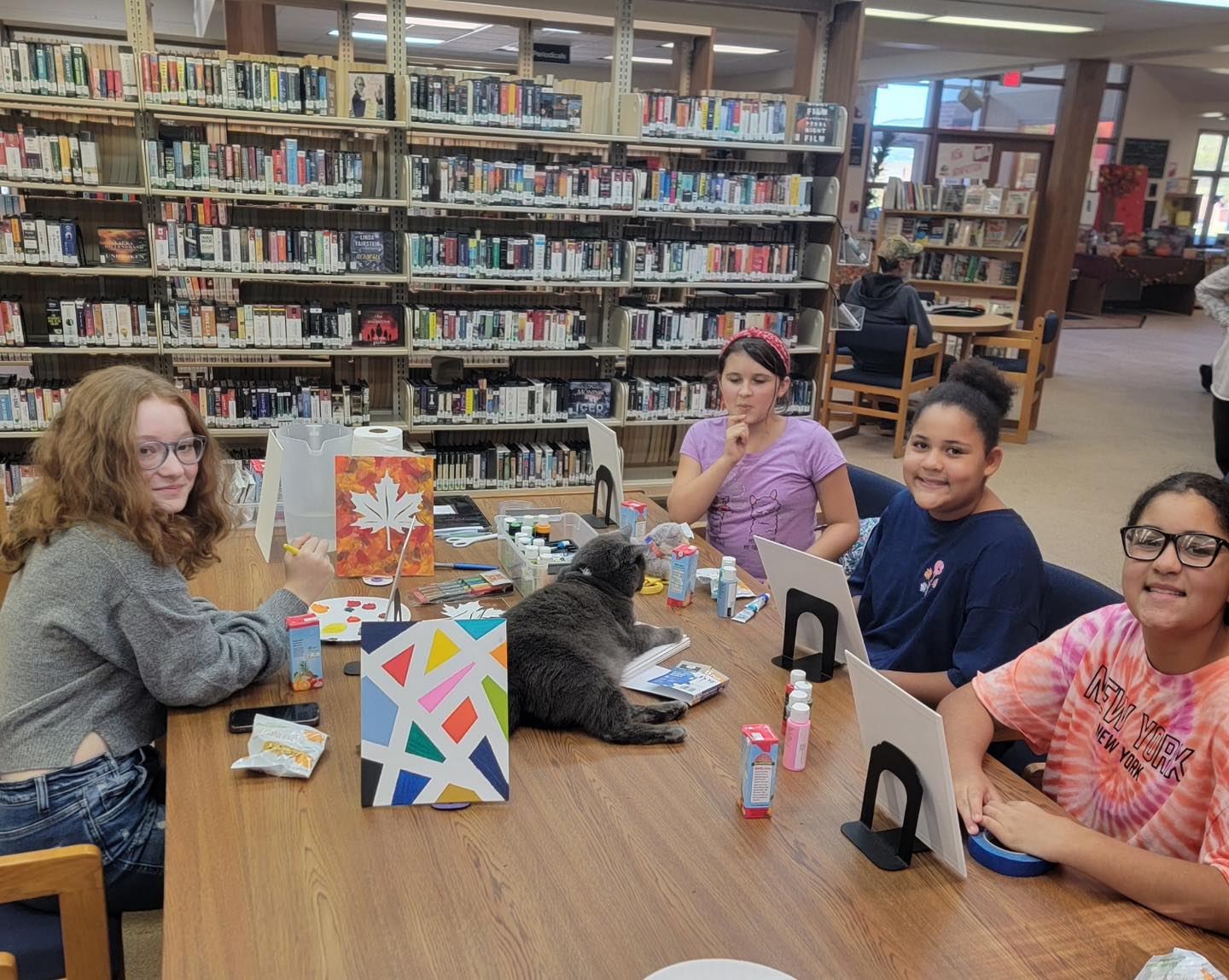 teens sitting at a table in the library